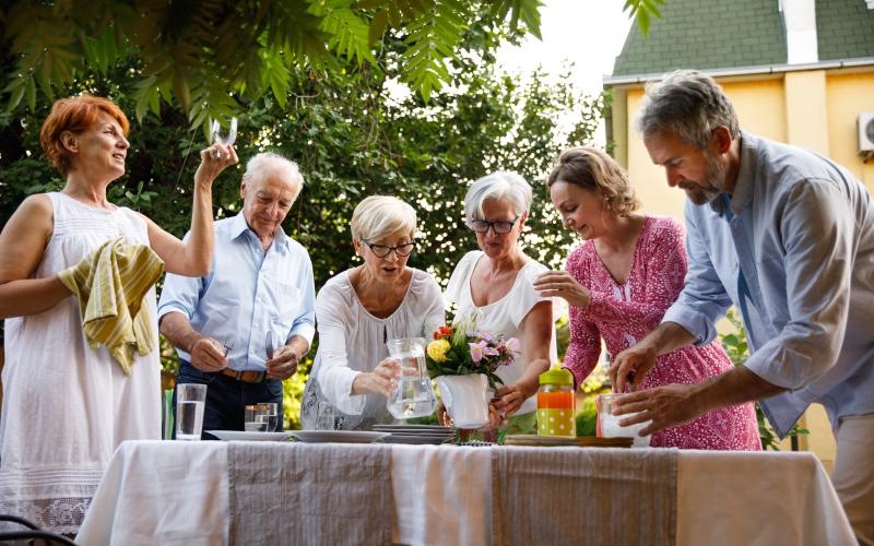 a group of people standing around a table with flowers