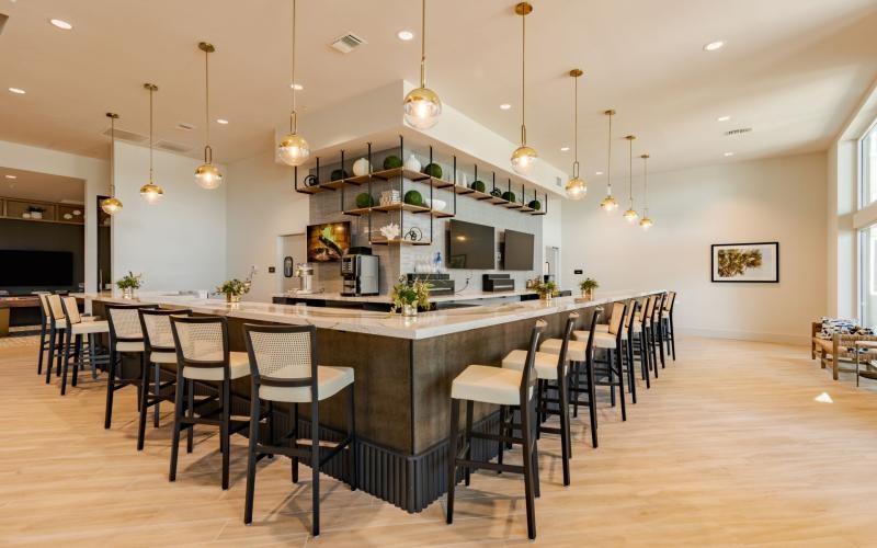 a large kitchen with a bar and chairs