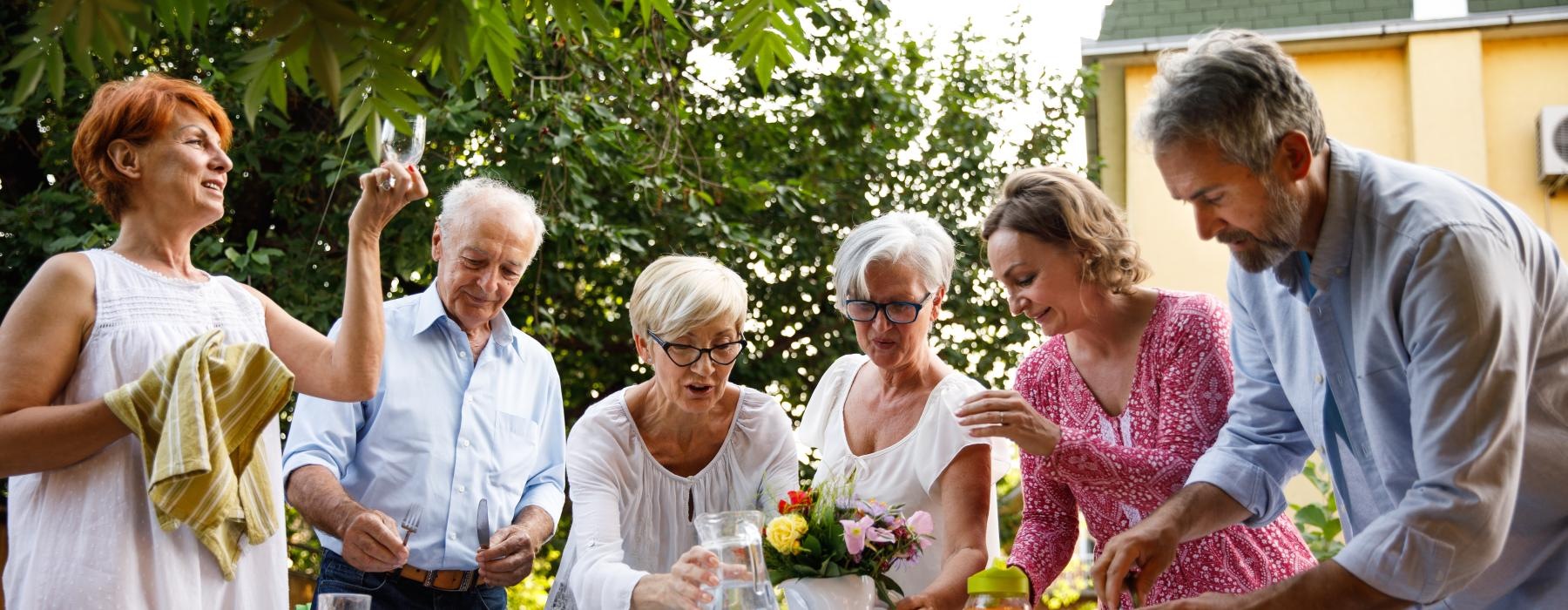 a group of people standing around a table with flowers